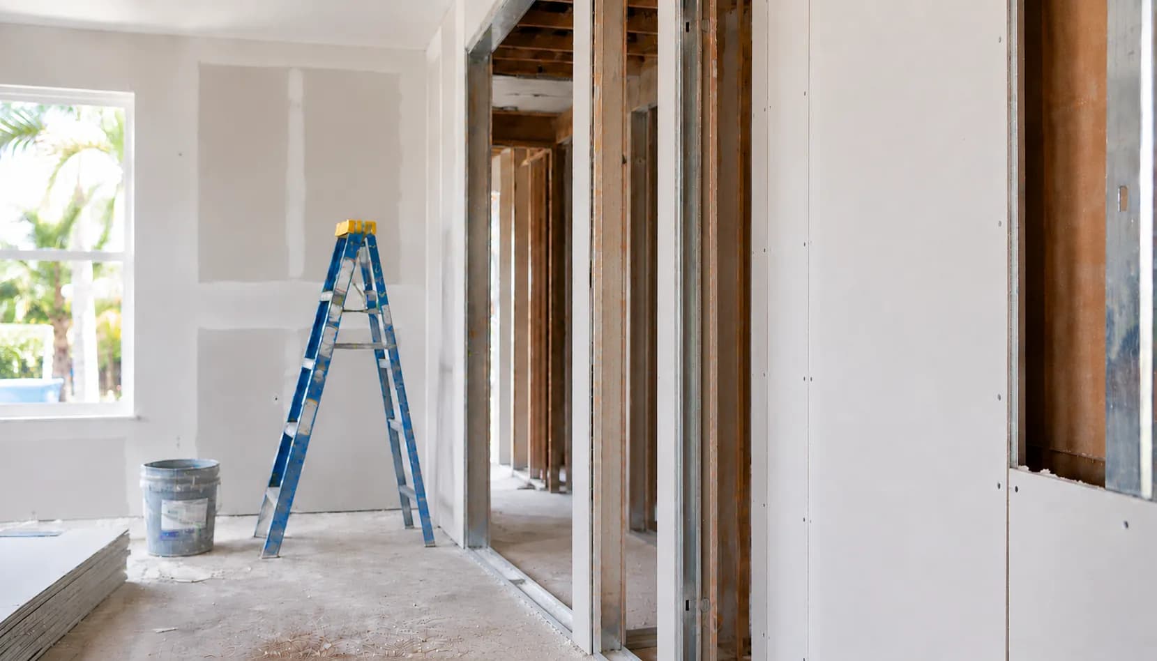 Interior mid-reconstruction with new framing, drywall, and ladder